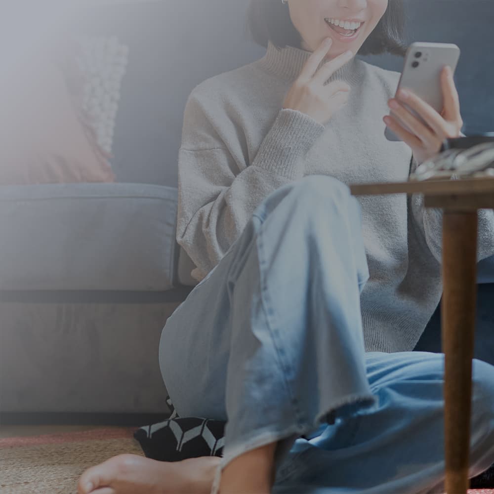앉아서 앱을 이용하는 사람 이미지